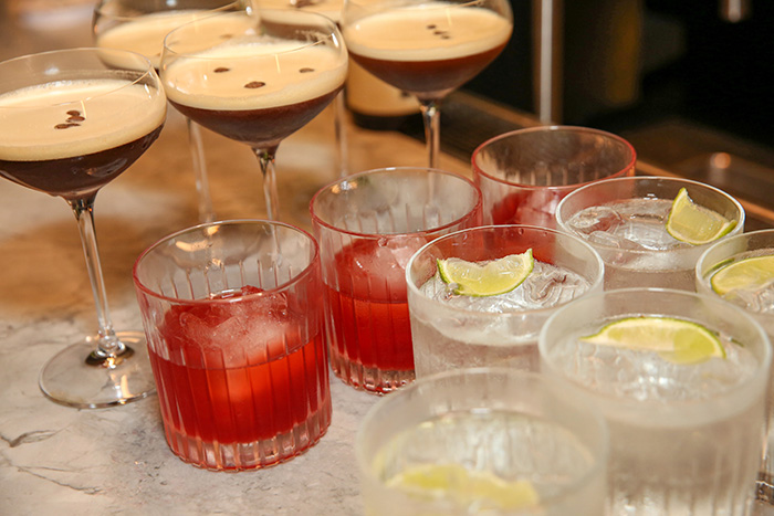 Colourful cocktails arranged on a bar.